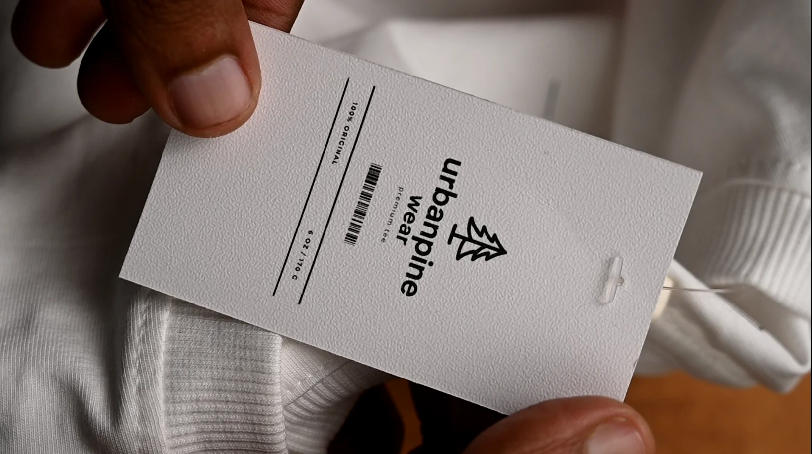 Hangtag held in hand showing brand name and barcode