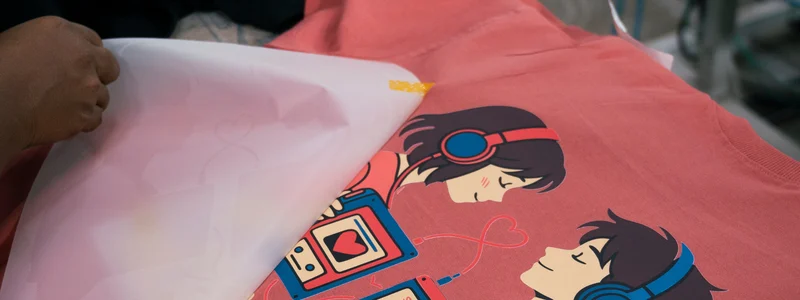 DTF transfer film being peeled off a custom printed t-shirt
