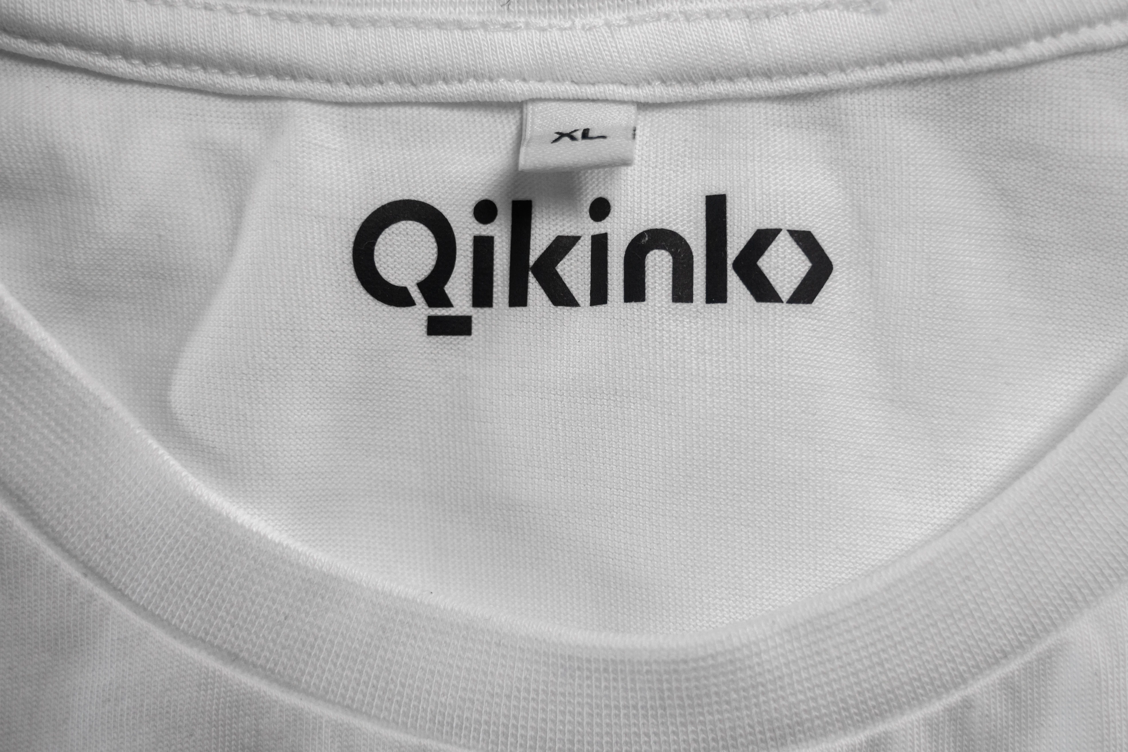 Black Qikink logo neck label on white t-shirt
